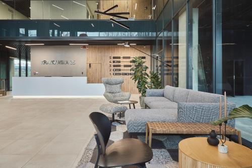 a lobby with a couch and chairs and tables at Aparthotel Symphony Krakowska 35 by INA in Wrocław
