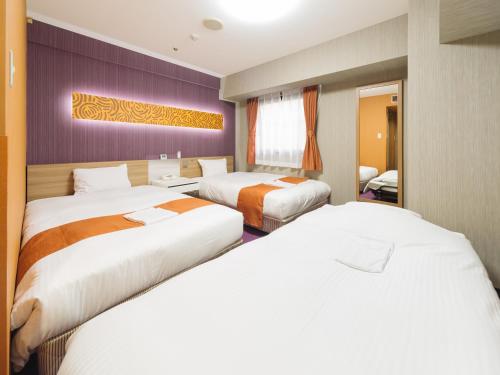 ein Hotelzimmer mit 2 Betten in einem Zimmer in der Unterkunft Hotel Wing International Nagoya in Nagoya