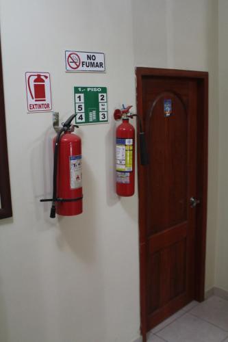 two fire hydrants on a wall next to a door at Hostal Rosa Mar in Manta