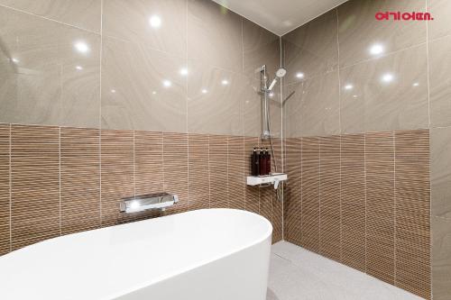 a bathroom with a shower and a tub and a toilet at INCHEON AIRPORT HOTEL THE ONe in Incheon
