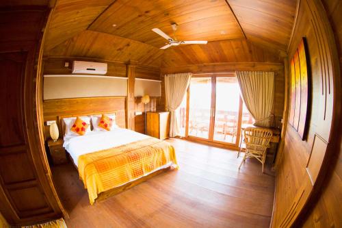 ein Schlafzimmer mit einem Bett und einem großen Fenster in der Unterkunft Vinis Farm - A Private Island Stay -Privacy Redefined !!! in Munroe Island