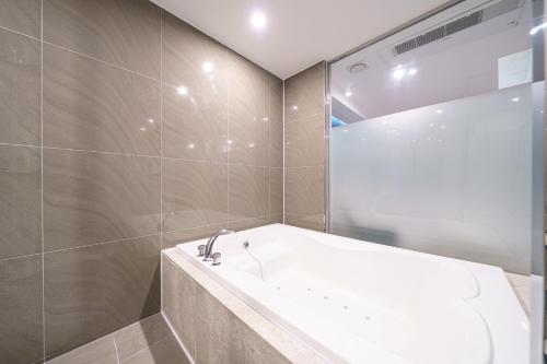 a bathroom with a bath tub and a shower at INCHEON AIRPORT HOTEL THE ONe in Incheon