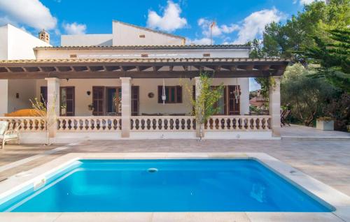 a villa with a swimming pool in front of a house at Pomeres Nou in Sa Coma
