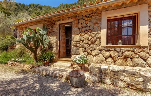 a stone house with a window and a barrel at Rustica Es Seguers in Fornalutx