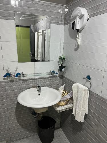 a bathroom with a sink and a mirror and towels at Rusty Rock Beach Resort & Spa in Mwanza