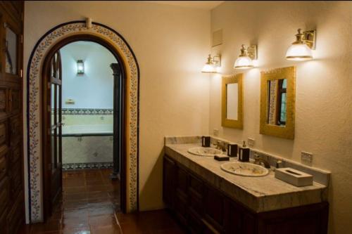 a bathroom with two sinks and a large mirror at La Casa Ideal Para Tu Estancia. in San Miguel de Allende