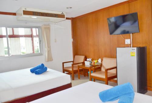 a room with two beds and a tv on a wall at At Bangkok Hotel in Bangkok