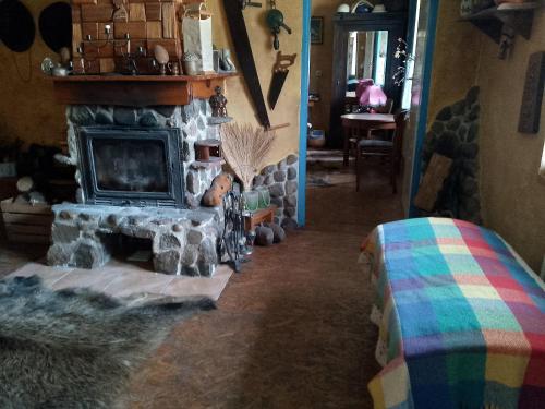 a living room with a stone fireplace and a table at Zagroda Zalipie in Gostynin