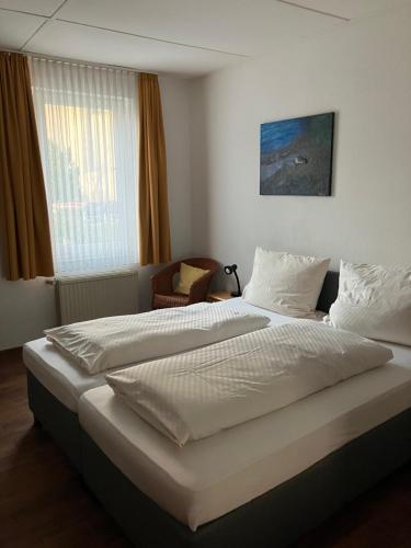 ein Schlafzimmer mit einem großen weißen Bett und einem Fenster in der Unterkunft Paciello Restaurant Hotel in Velbert
