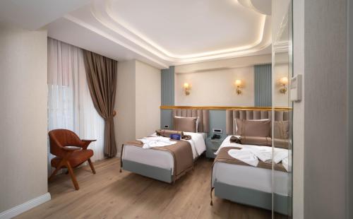a hotel room with two beds and a chair at De Bonte in Istanbul
