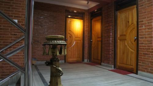 a fire hydrant in a brick hallway with two doors at City Guest House in Bhaktapur