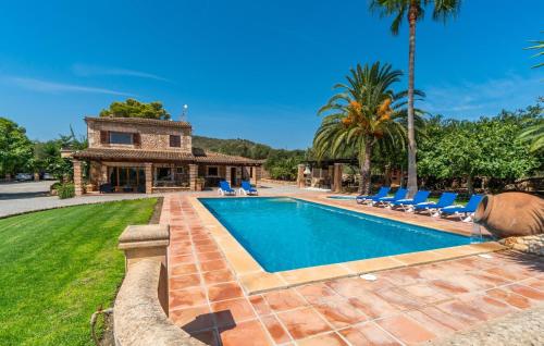 a swimming pool with chairs and a house at Bosco in Sa Coma