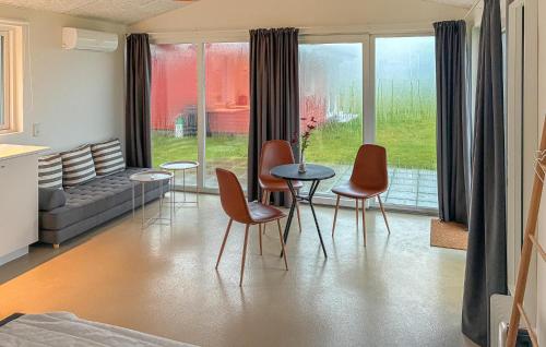 a living room with chairs and a table and a couch at Beach Front Home In Samsø With House Sea View in Kolby Kås