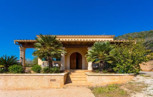 a small house with palm trees in front of it at Can Safiro in Son Servera