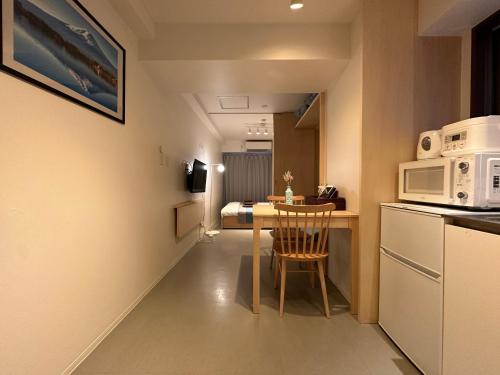 a small kitchen with a table and a microwave at nestay apartment tokyo shinjuku in Tokyo