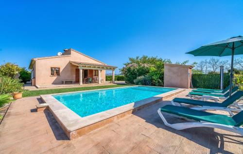 a swimming pool with two chairs and an umbrella at S'hortet Gran in Alcudia