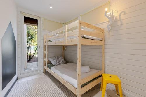 a bunk bed in a room with a yellow stool at Villa de rêve - Climatisation - Sauna - Spa - babyfoot - Arcade in Quatzenheim