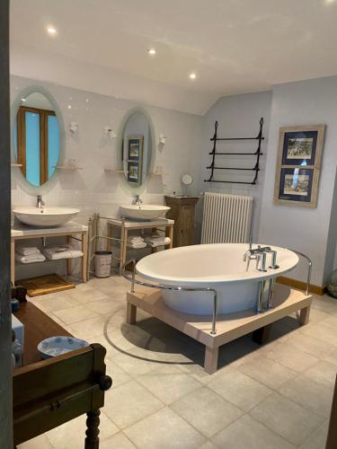 a large bathroom with two sinks and a large tub at Carpe diem in Massangis