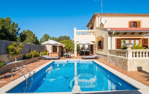 a villa with a swimming pool in front of a house at Manrique in Cala Ratjada