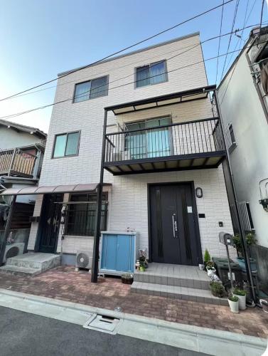 a white brick house with a black door at 直达-池袋-2分钟 车站徒步6分钟 3bedrooms-IT0338 in Tokyo