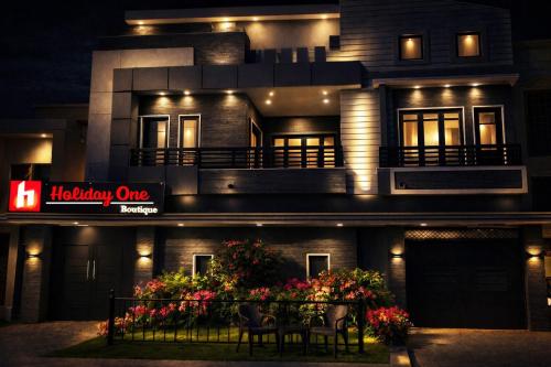 a building with a table in front of it at night at Holiday One Hotel & Suites - Expo Center in Karachi