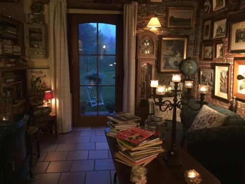 a room with a table with books and a window at La Remise - Les Chambres in Neufchâteau