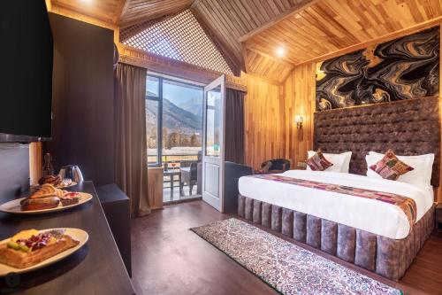 a hotel room with a large bed and a balcony at Hotel Classy Castle in Kolur
