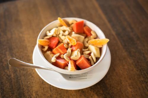 a bowl of pasta and carrots on a plate with a fork at Simrose in Agonda