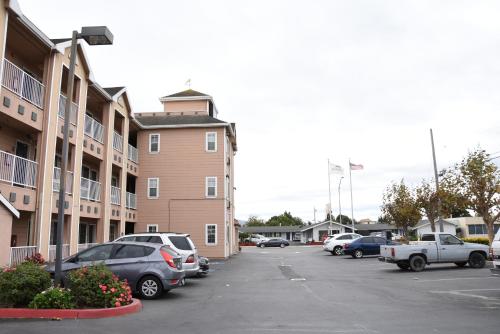 a parking lot with cars parked in front of a building at Howard Johnson by Wyndham Salinas in Salinas