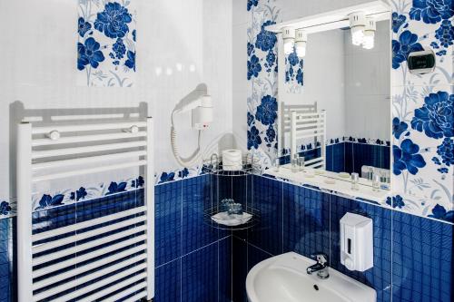 a blue and white bathroom with a sink and a mirror at Pensiunea Siva in Horezu