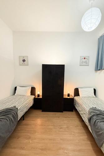 a room with two beds and a black cabinet at 2Stay Porto in Porto