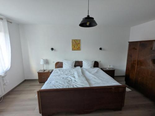 a bedroom with a large bed with white sheets at LOGEMENT 110m2 CHEZ TITI in Ittenheim
