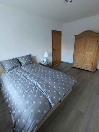 a bedroom with a large bed and a wooden cabinet at LOGEMENT 110m2 CHEZ TITI in Ittenheim