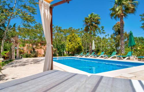 a view of a swimming pool with a bed and chairs at Pambola in Caʼs Concos