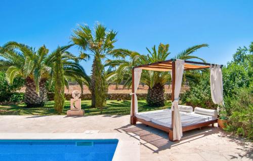 a bed with a canopy next to a pool at Pambola in Caʼs Concos