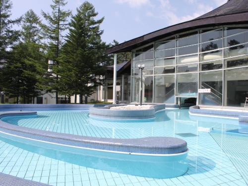 a swimming pool in front of a building at Kusatsu Onsen Hotel Village in Kusatsu