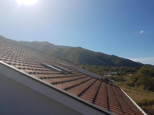 a roof on a building with mountains in the background at Podgorski An in Kolešino