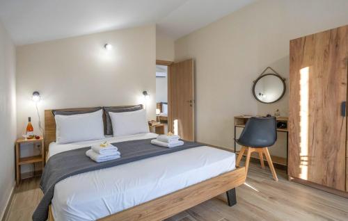 una camera da letto con un grande letto e uno specchio di Olive Waves apartments a Néa Péramos