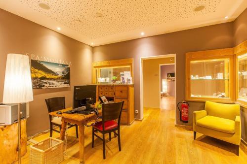 a dining room with a table and a yellow chair at Hotel Rosatsch in Pontresina