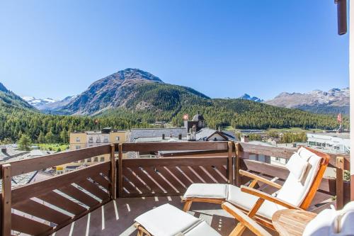 a balcony with two chairs and a view of mountains at Hotel Rosatsch in Pontresina