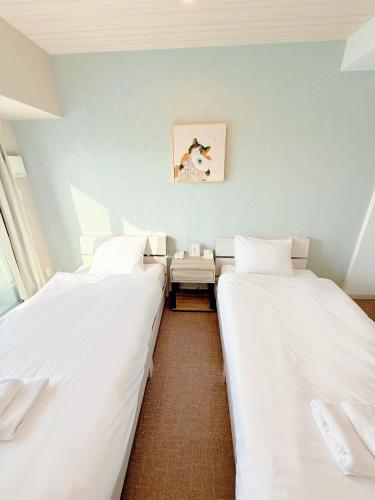 two beds sitting next to each other in a room at Hoshino Stay 2 Near Namba 3-Min Walk to Station in Osaka