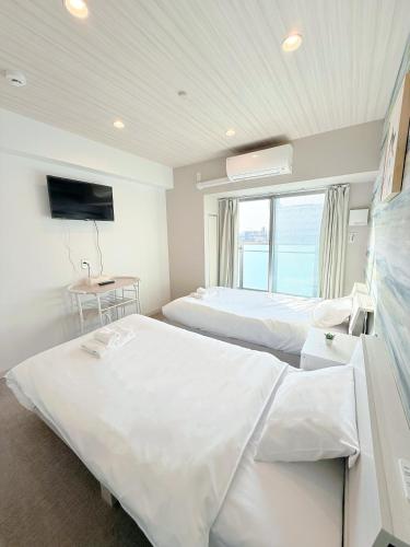 a hotel room with two beds and a television at Hoshino Stay 2 Near Namba 3-Min Walk to Station in Osaka