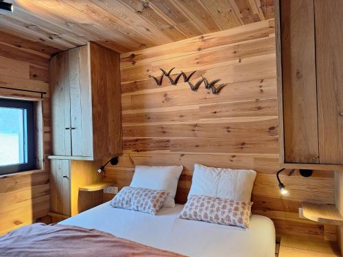 a bedroom with a bed in a wooden wall at La Bucolique de Tahier in Ohey