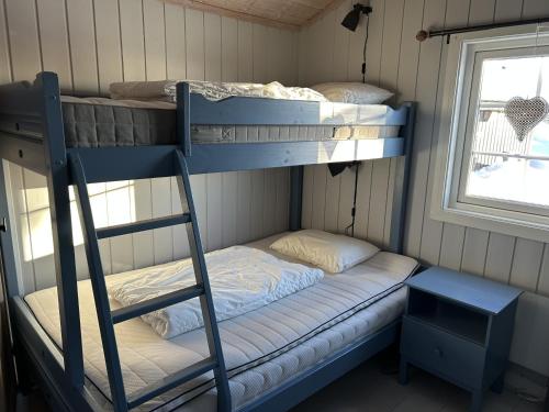 two bunk beds in a room with a window at Mountain cabin in Lillehammer in Lillehammer