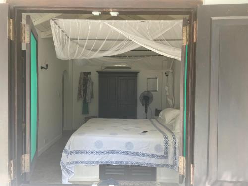 a bed with a canopy in a white bedroom at Cinnamon lodge rooms in Koggala