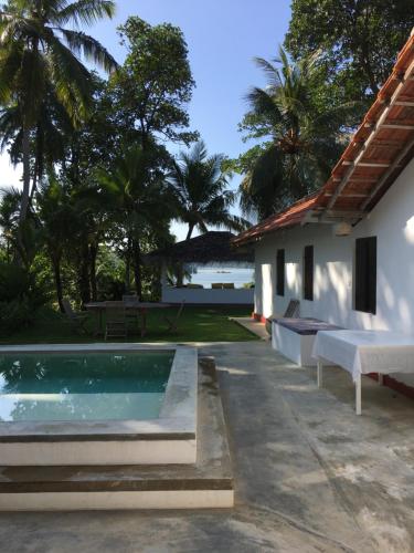 a swimming pool in front of a villa at Cinnamon lodge rooms in Koggala