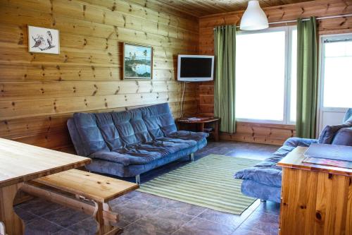 sala de estar con sofá azul y TV en Ounasvaara Sport Cottages, en Rovaniemi