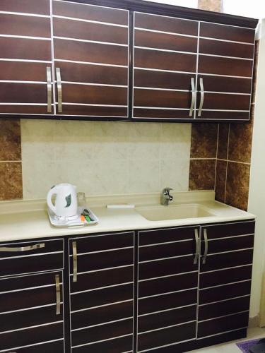 a kitchen counter with a sink and a sink at مساكن الرها للشقق المخدومة in Dammam
