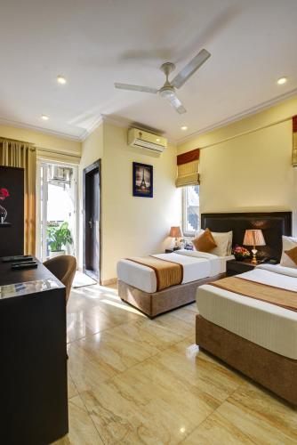 a hotel room with two beds and a bathroom at Anand Bhawan in New Delhi