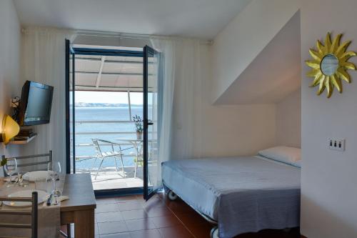 a bedroom with a bed and a view of the ocean at Apartments Miki in Donja Klada